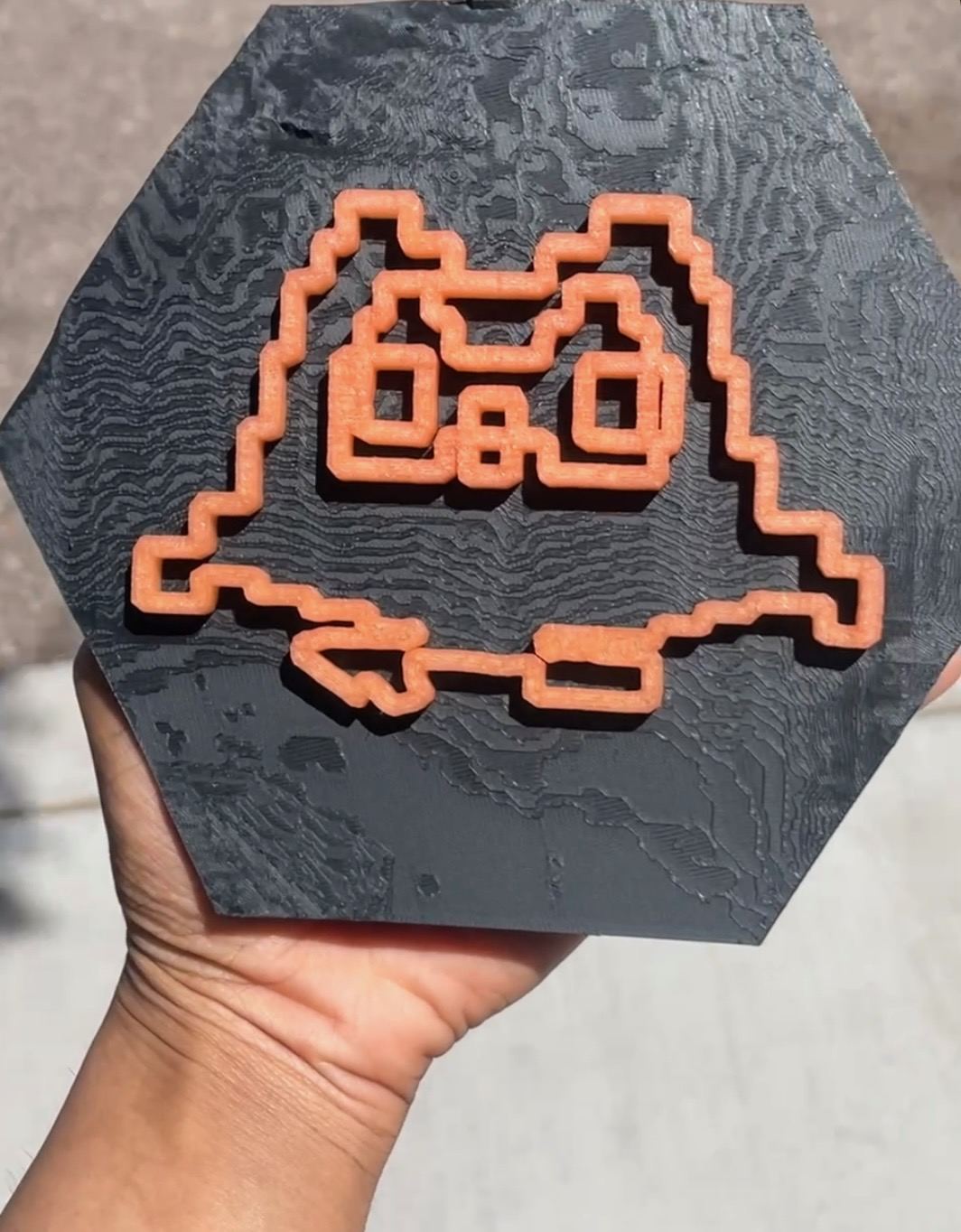 Custom topo trail trophy - 3D printed Strava route glowing orange in sunlight